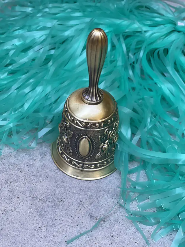 A brass bell on teal ribbon, rung to mark the end of chemotherapy.